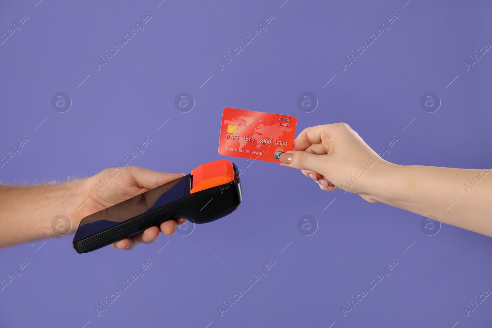 Photo of Man taking payment from client via terminal on purple background, closeup