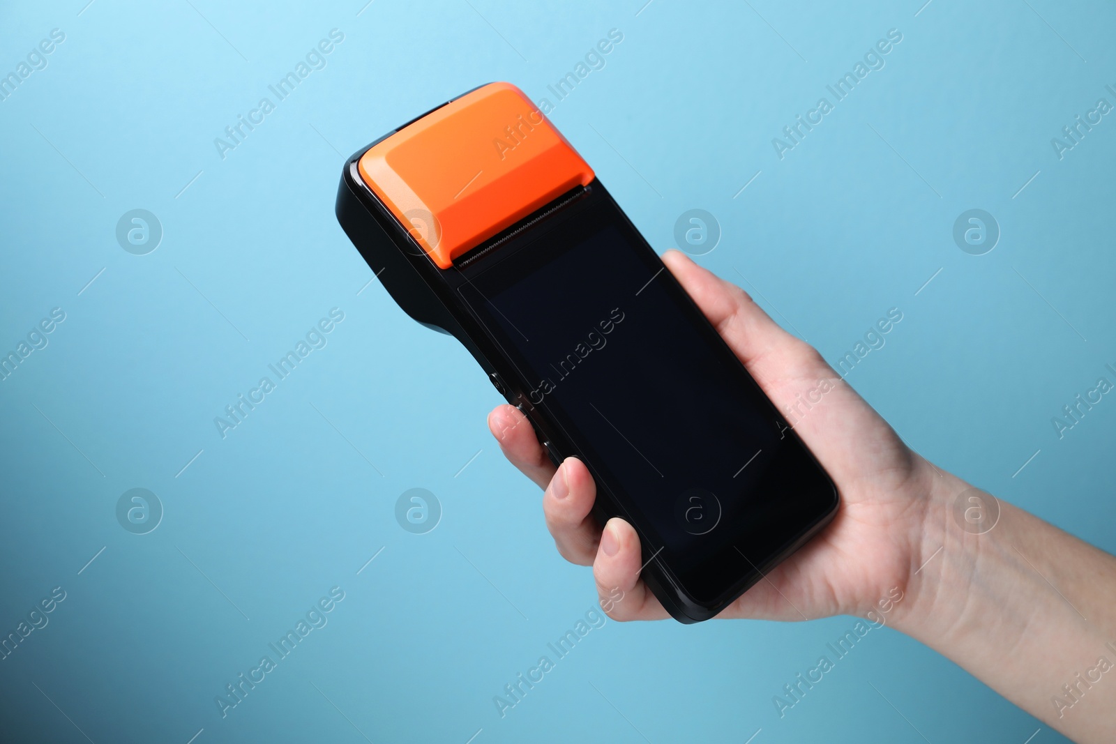 Photo of Woman with payment terminal on light blue background, closeup. Space for text