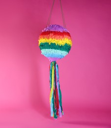 Photo of One colorful pinata on bright pink background