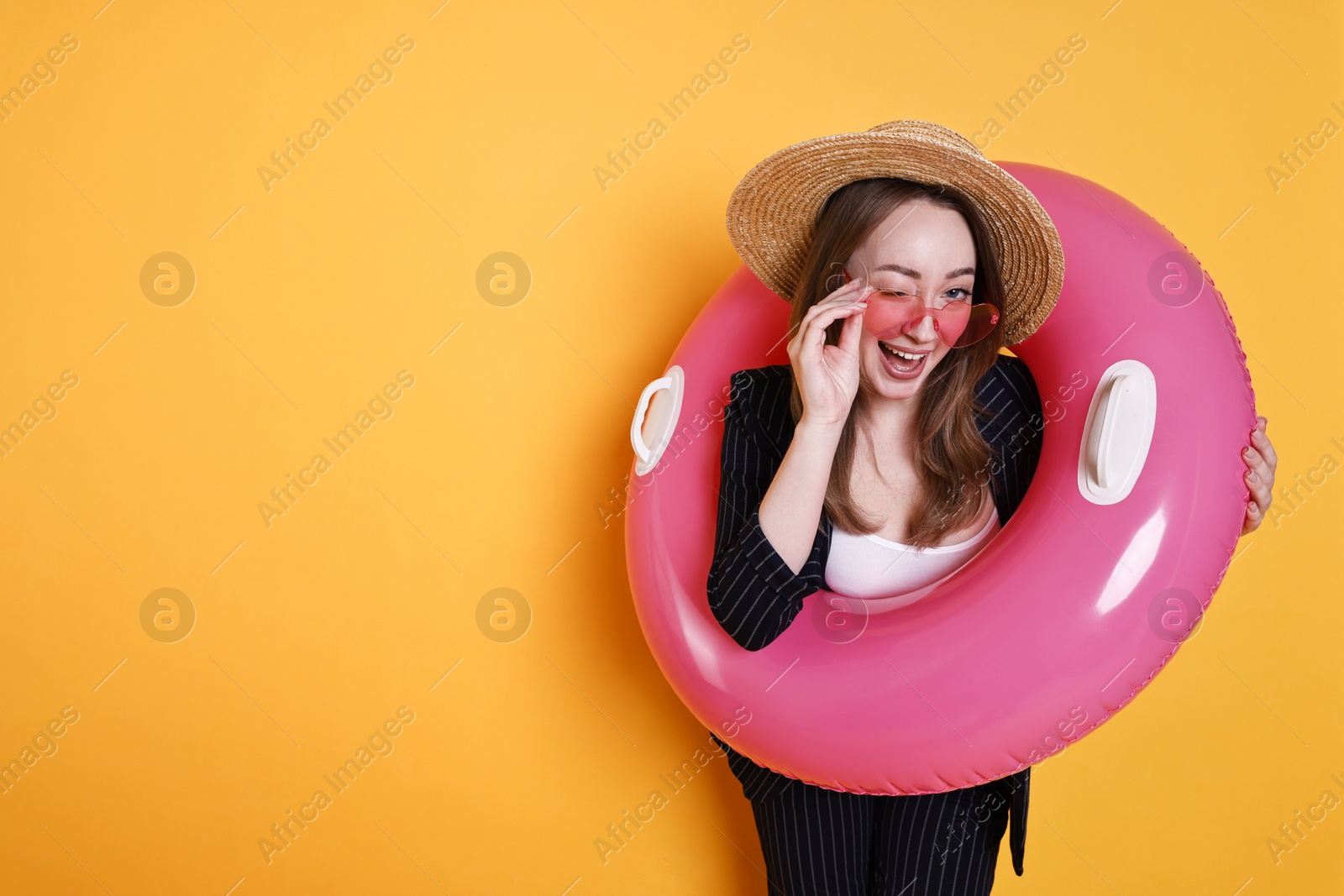 Photo of Businesswoman with inflatable ring, straw hat and sunglasses on orange background, space for text