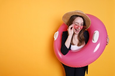 Photo of Businesswoman with inflatable ring, straw hat and sunglasses on orange background, space for text