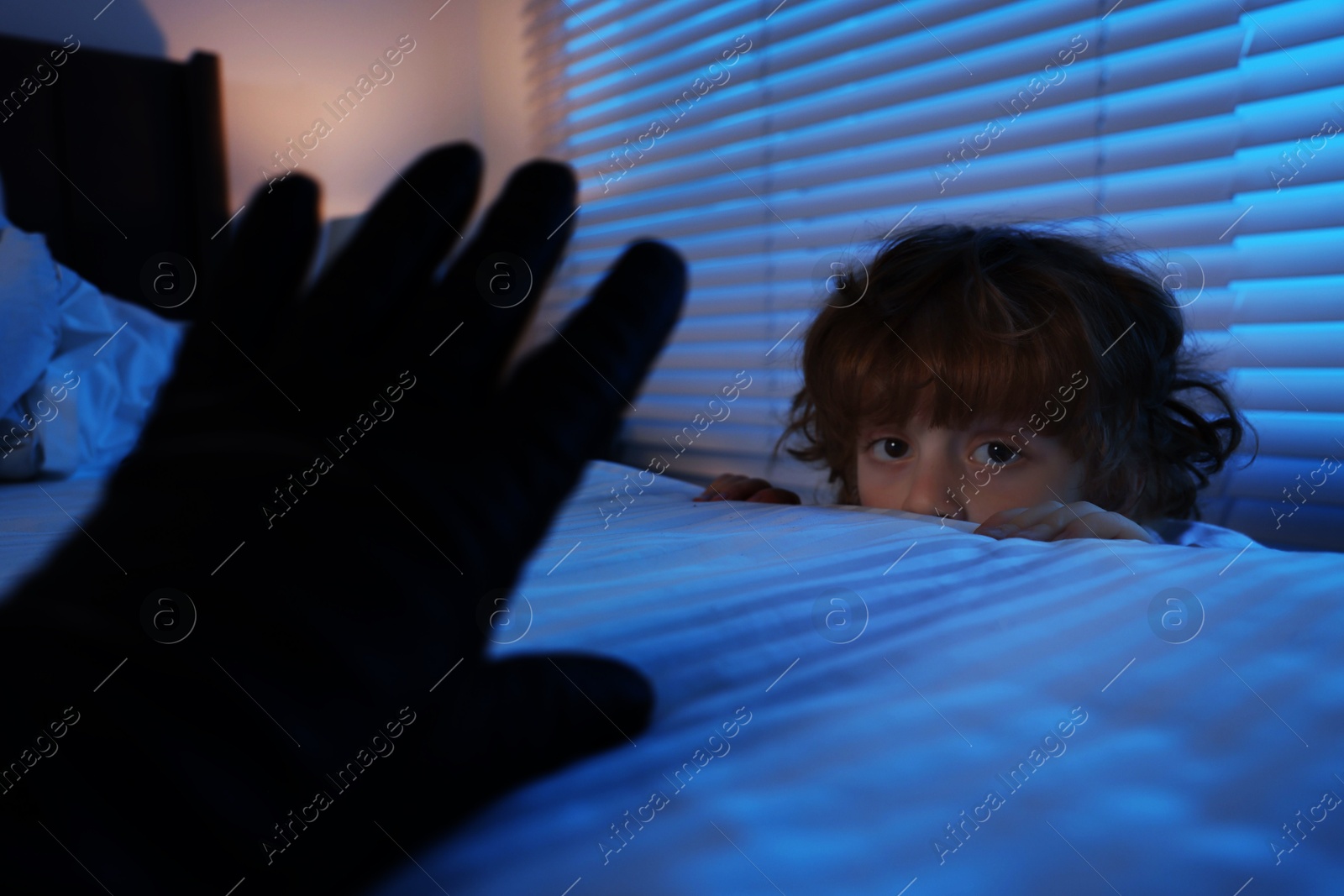 Photo of Bogeymen reaching for scared boy in bedroom at night, closeup