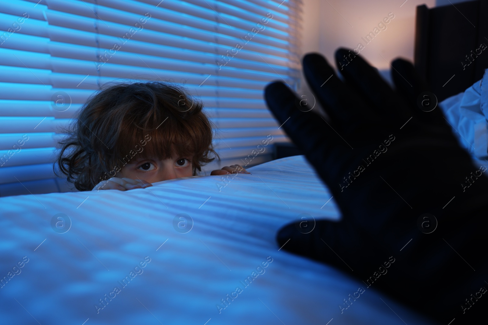 Photo of Bogeymen reaching for scared boy in bedroom at night, closeup