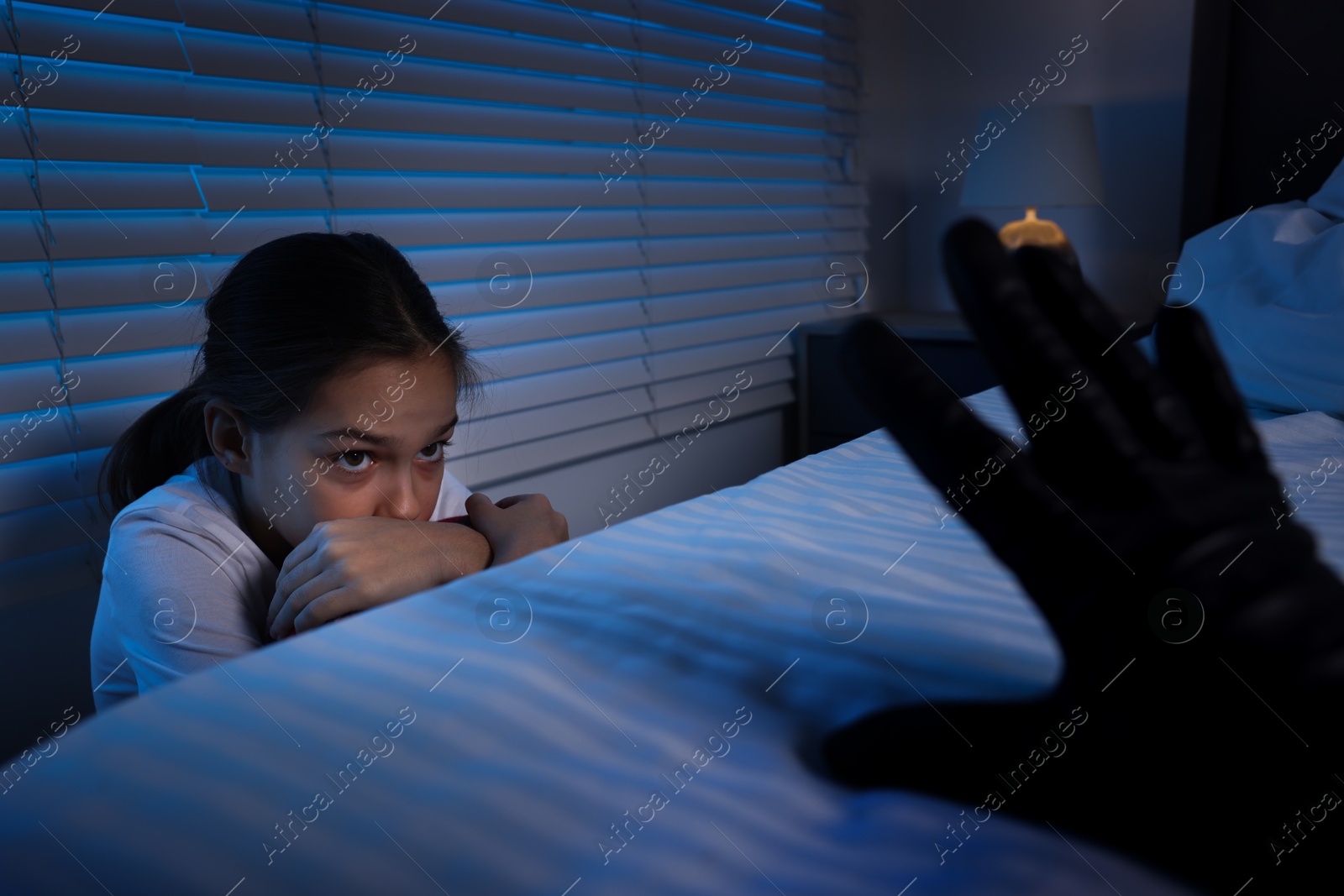 Photo of Bogeymen reaching for scared girl in bedroom at night, closeup