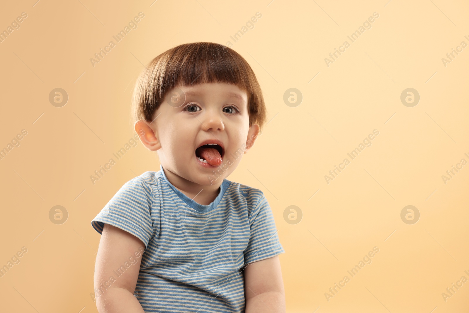 Photo of Portrait of cute little boy on beige background. Space for text