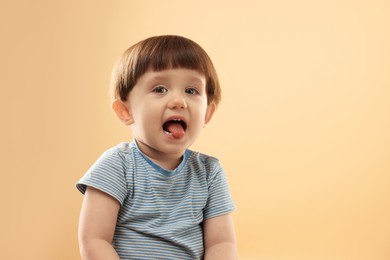 Photo of Portrait of cute little boy on beige background. Space for text