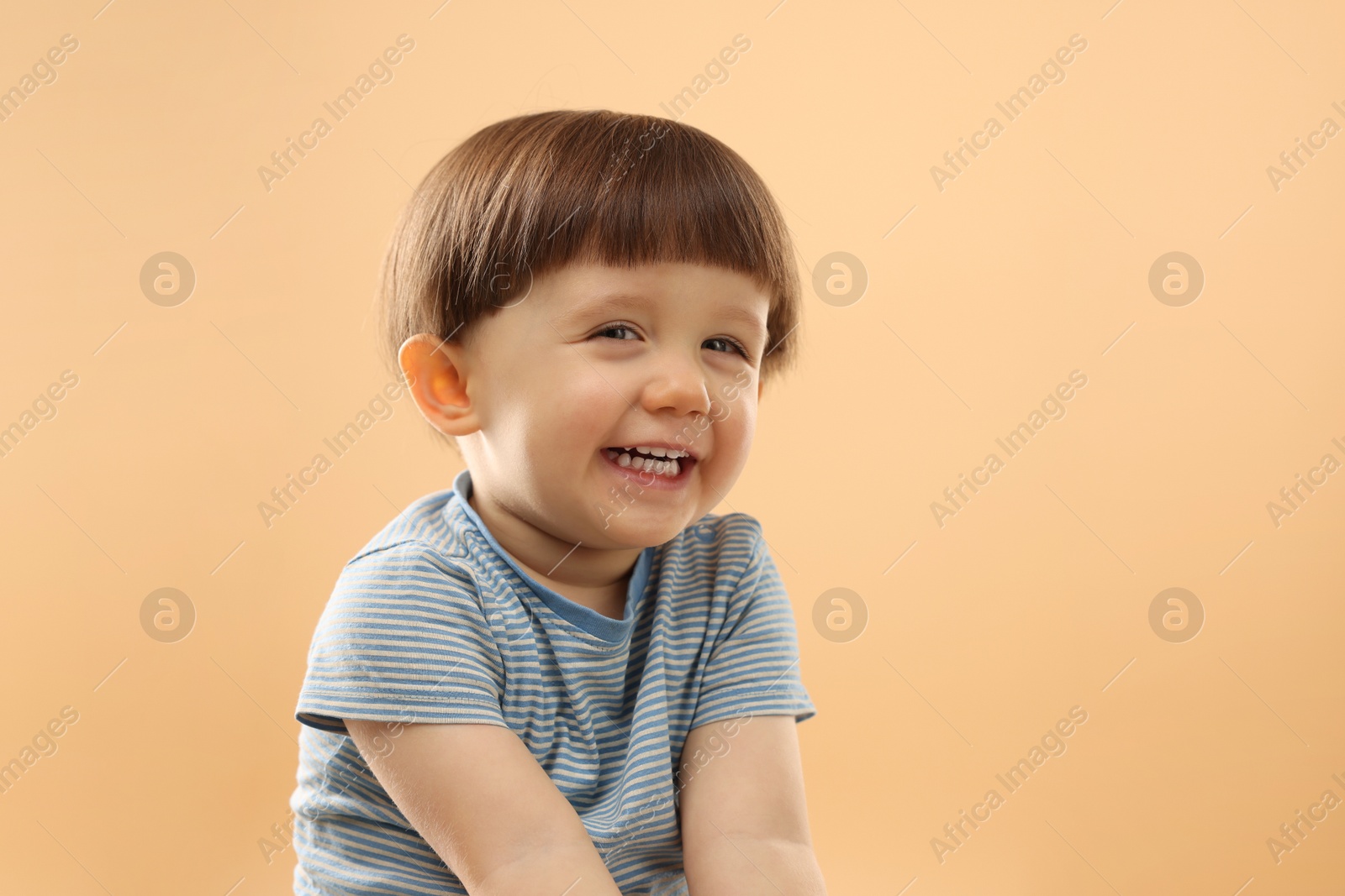 Photo of Portrait of happy little boy on beige background. Space for text