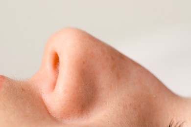 Woman with normal nasal septum on light background, closeup