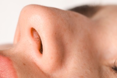 Woman with normal nasal septum on light background, closeup