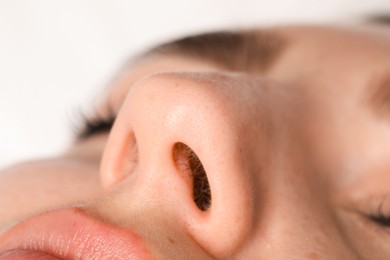 Woman with normal nasal septum on light background, closeup