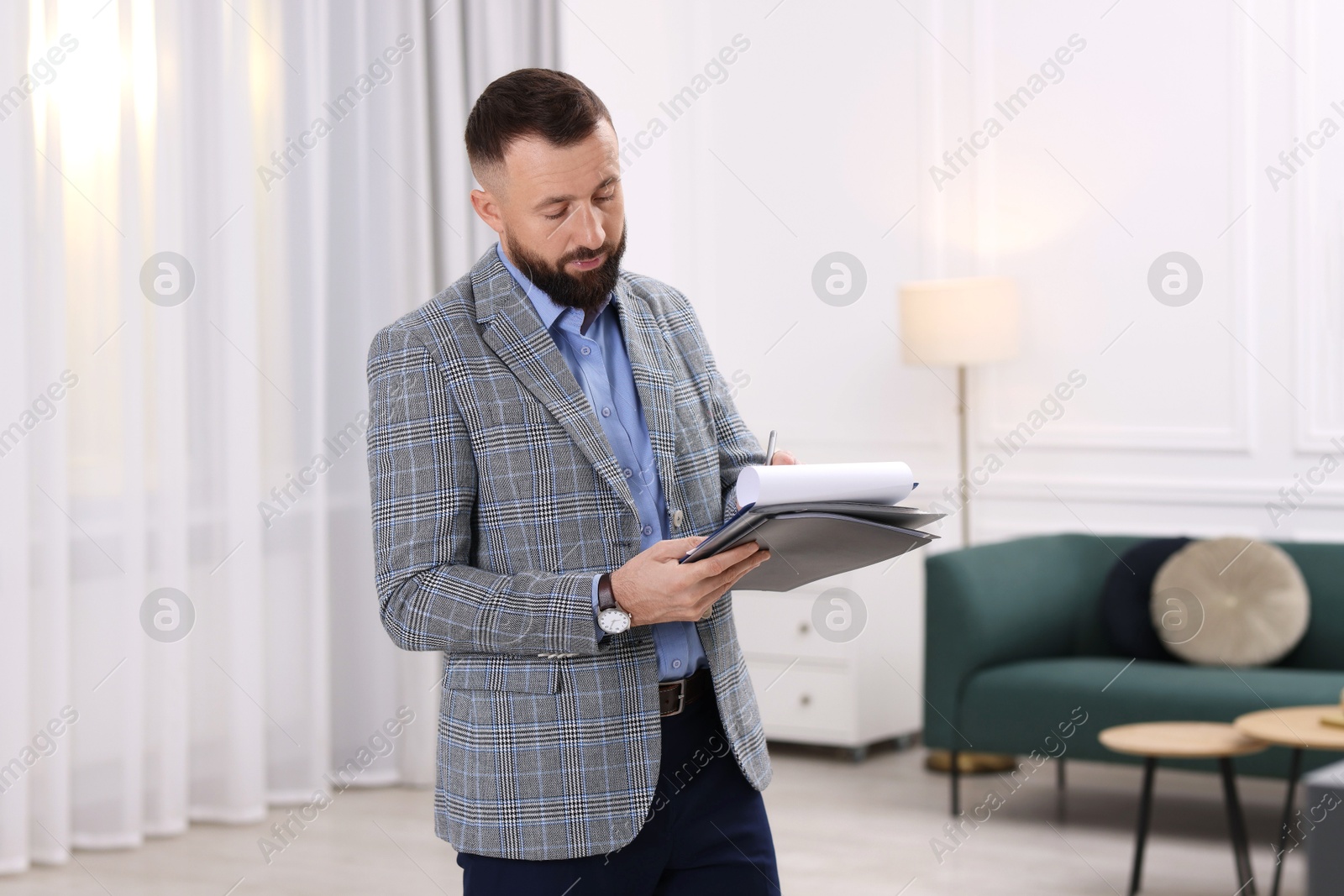 Photo of Real estate appraisal. Inspector with clipboard conducting property valuation indoors