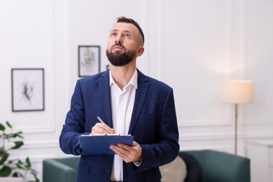 Real estate appraisal. Inspector with clipboard conducting property valuation indoors