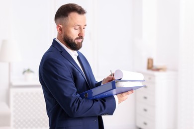 Photo of Real estate appraisal. Inspector with clipboard conducting property valuation indoors