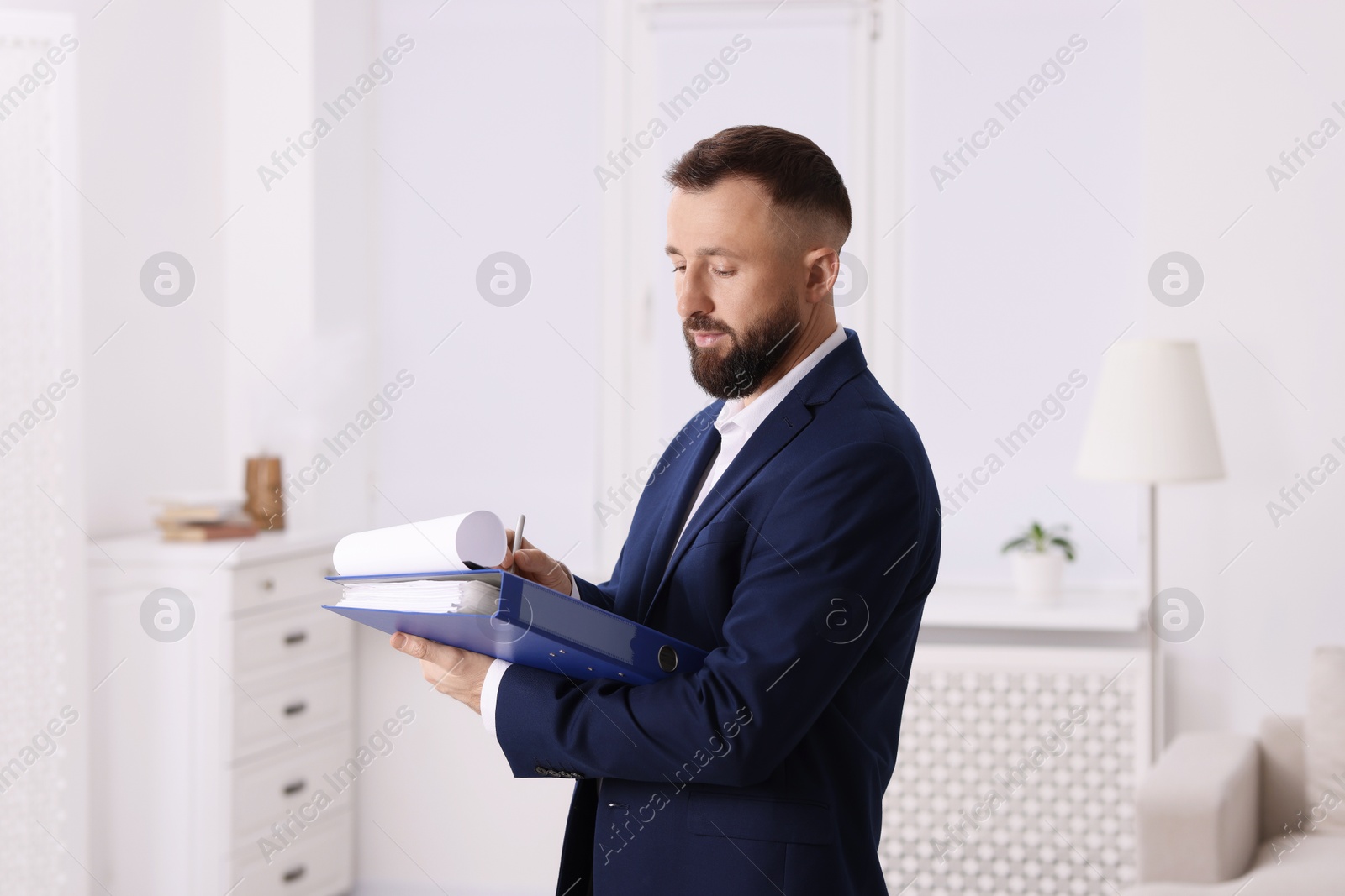 Photo of Real estate appraisal. Inspector with clipboard conducting property valuation indoors