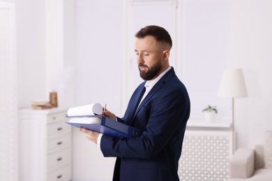 Real estate appraisal. Inspector with clipboard conducting property valuation indoors