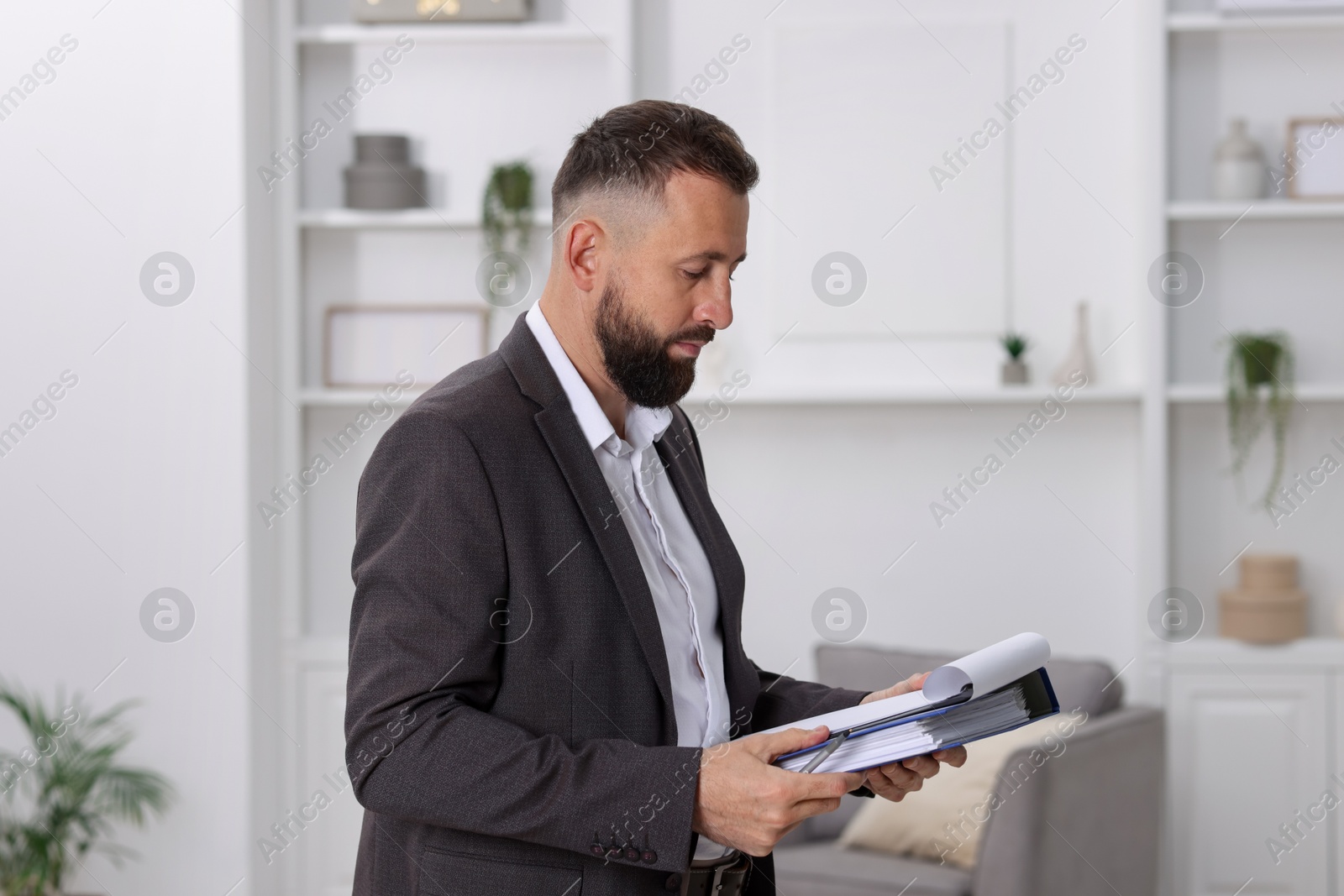 Photo of Real estate appraisal. Inspector with clipboard conducting property valuation indoors