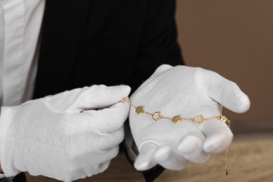 Photo of Appraiser with luxury jewelry on brown background, closeup