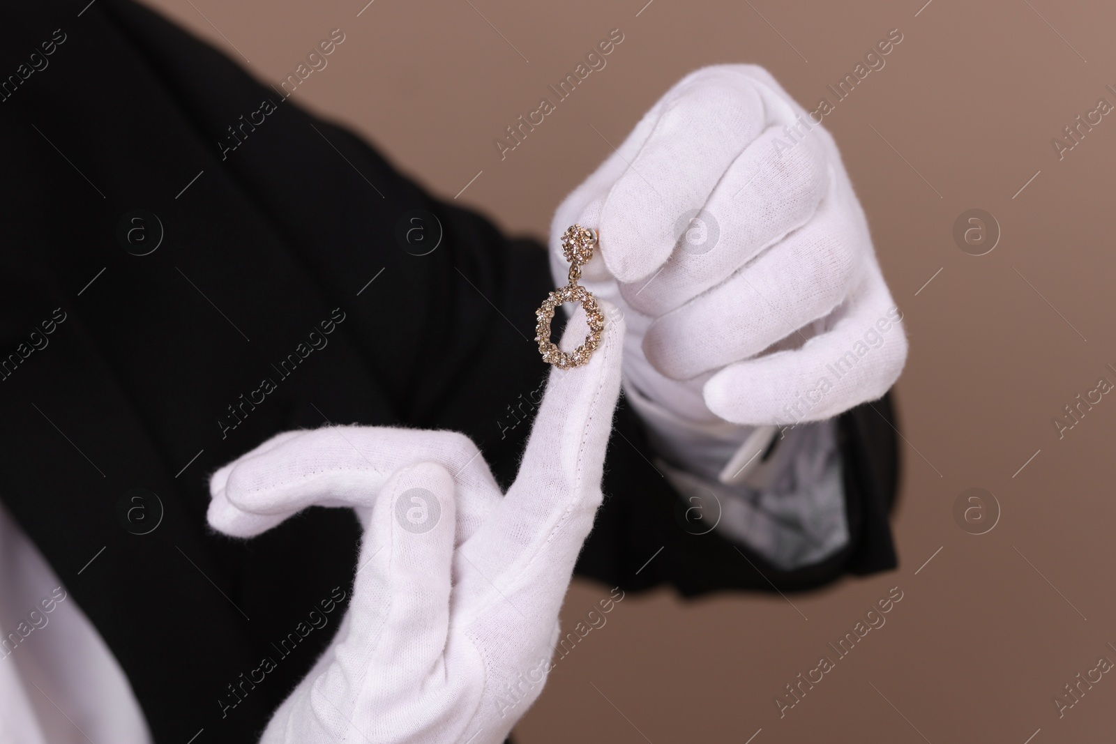 Photo of Appraiser with luxury jewelry on brown background, closeup