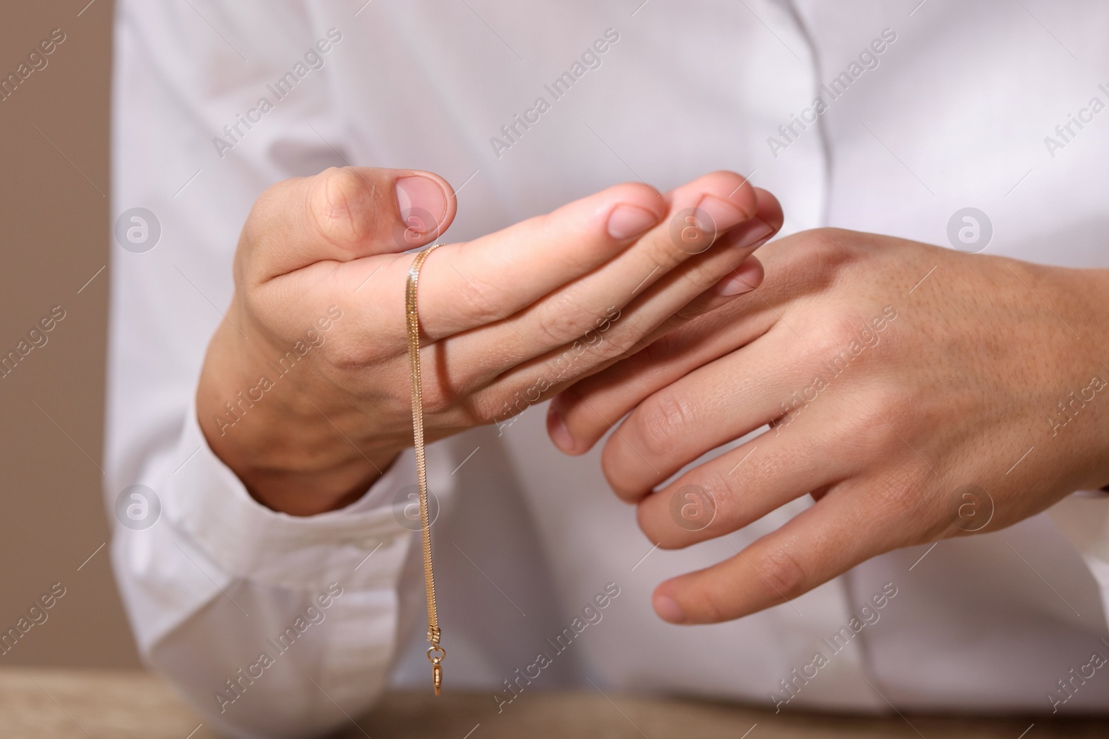 Photo of Appraiser with luxury jewelry on beige background, closeup