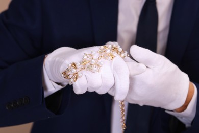 Photo of Appraiser in gloves with luxury jewelry, closeup