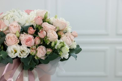 Photo of Bouquet of beautiful flowers and eucalyptus branches against blurred background, closeup. Space for text