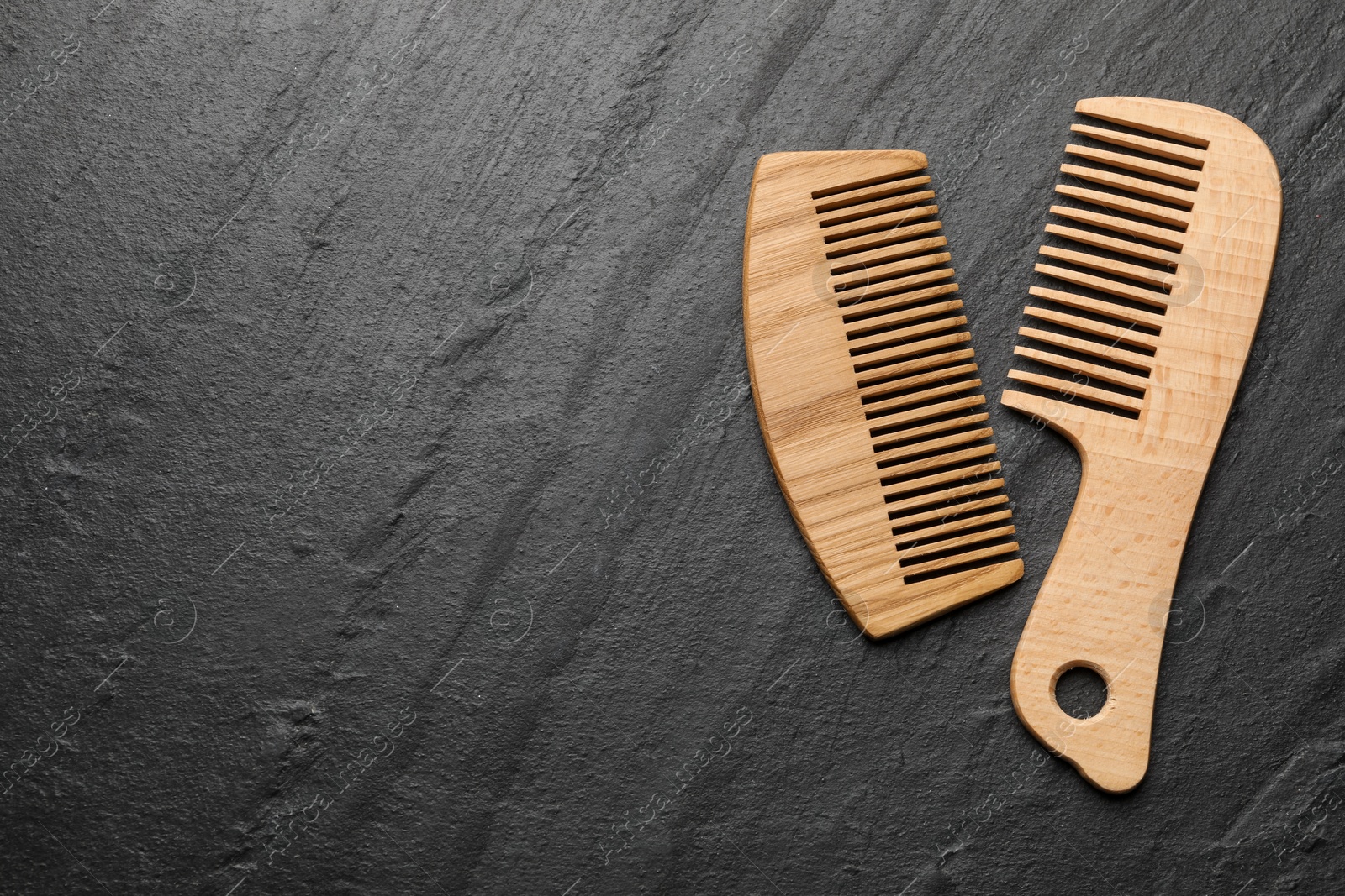 Photo of Different wooden hair combs on grey background, top view. Space for text