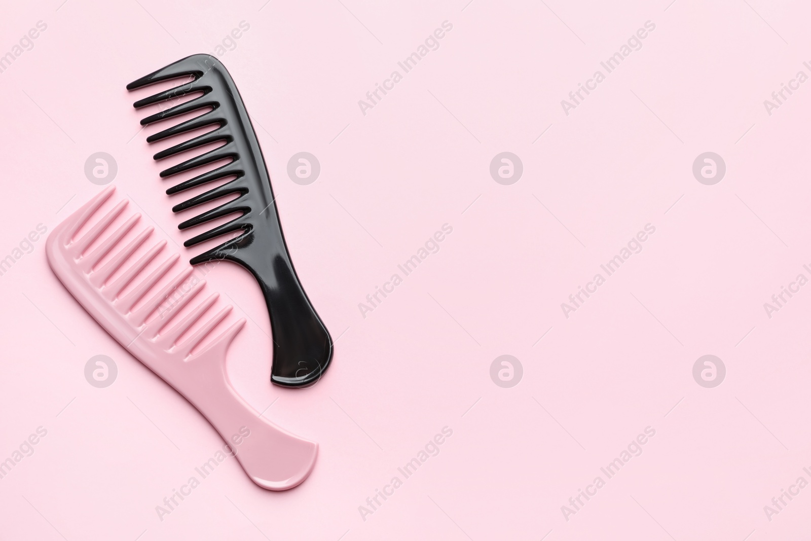 Photo of Different plastic hair combs on pink background, top view. Space for text