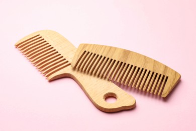 Photo of Different wooden hair combs on pink background, closeup