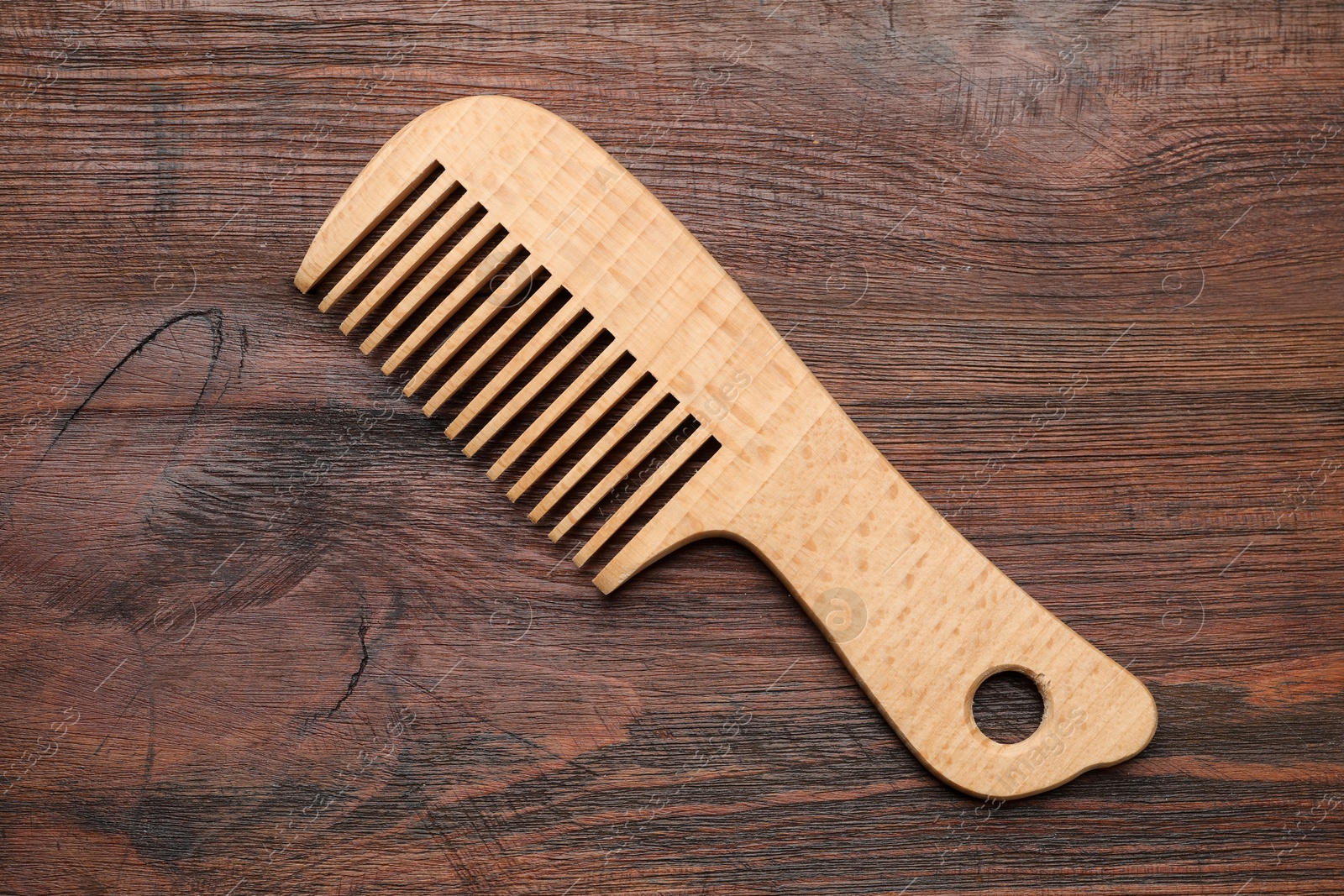 Photo of One hair comb on wooden background, top view