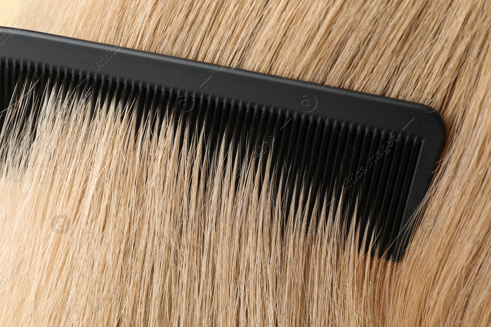 Photo of Brushing hair with plastic comb, closeup view