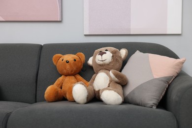 Photo of Teddy bears and pillow on sofa in room