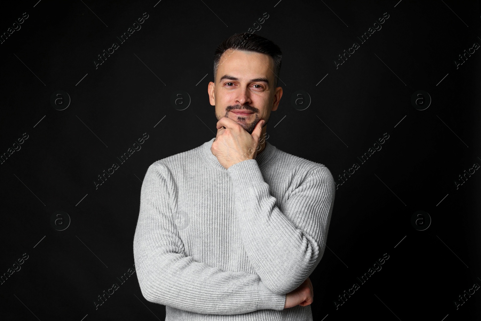 Photo of Portrait of handsome middle aged man on black background