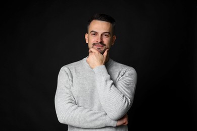 Portrait of handsome middle aged man on black background