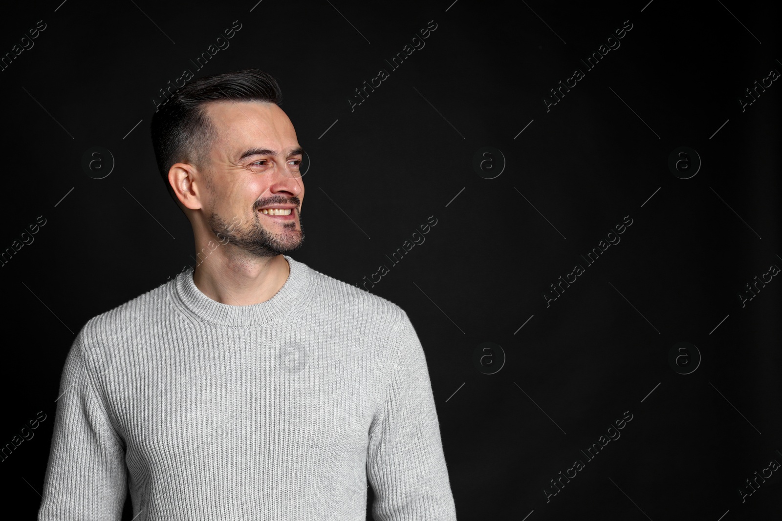 Photo of Portrait of handsome middle aged man on black background, space for text