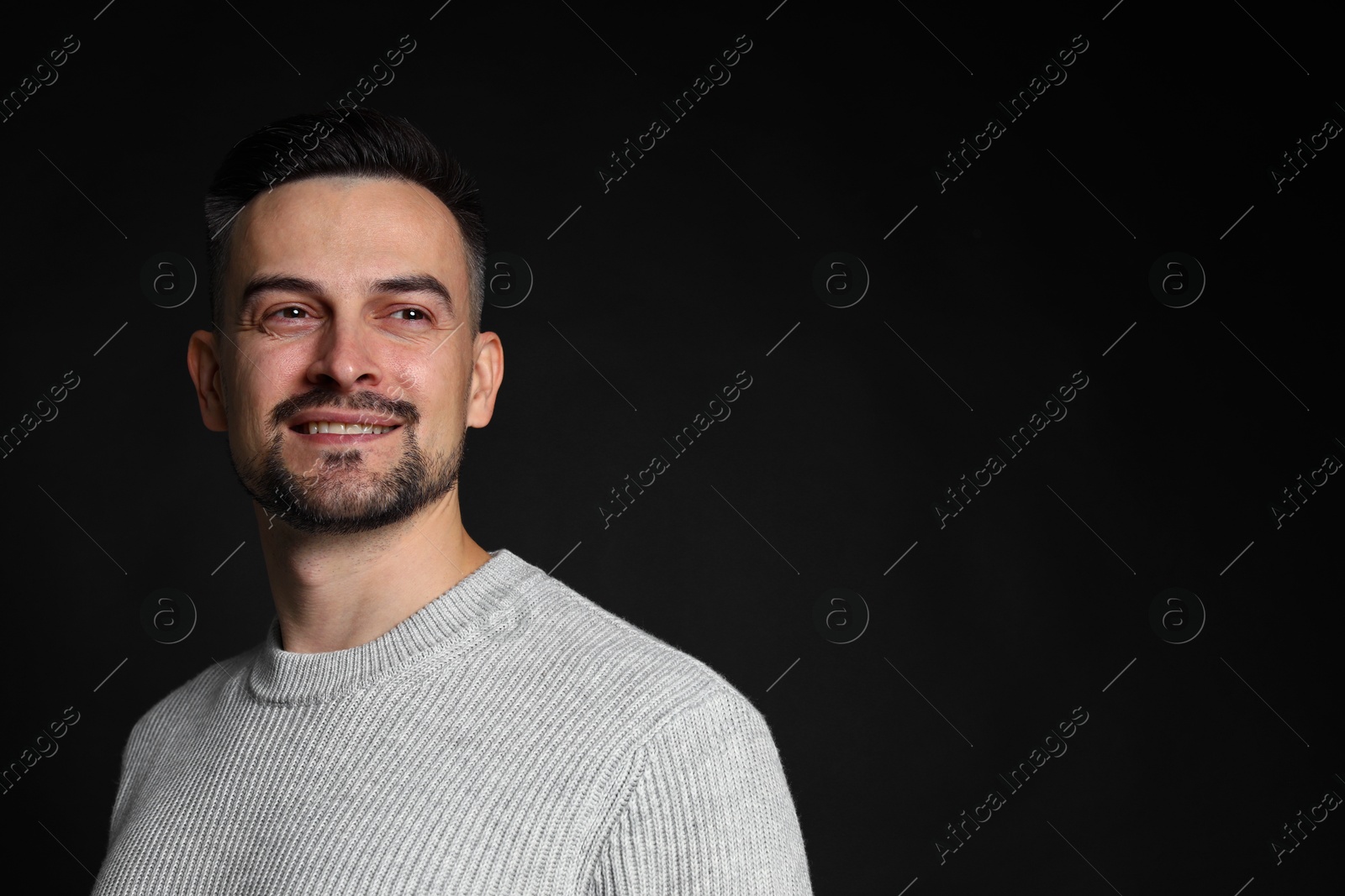 Photo of Portrait of handsome middle aged man on black background, space for text