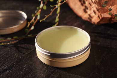 Photo of Natural solid perfume on black table, closeup