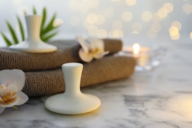 Photo of Spa stones, orchid flowers, towels and leaf on white marble table, closeup. Space for text