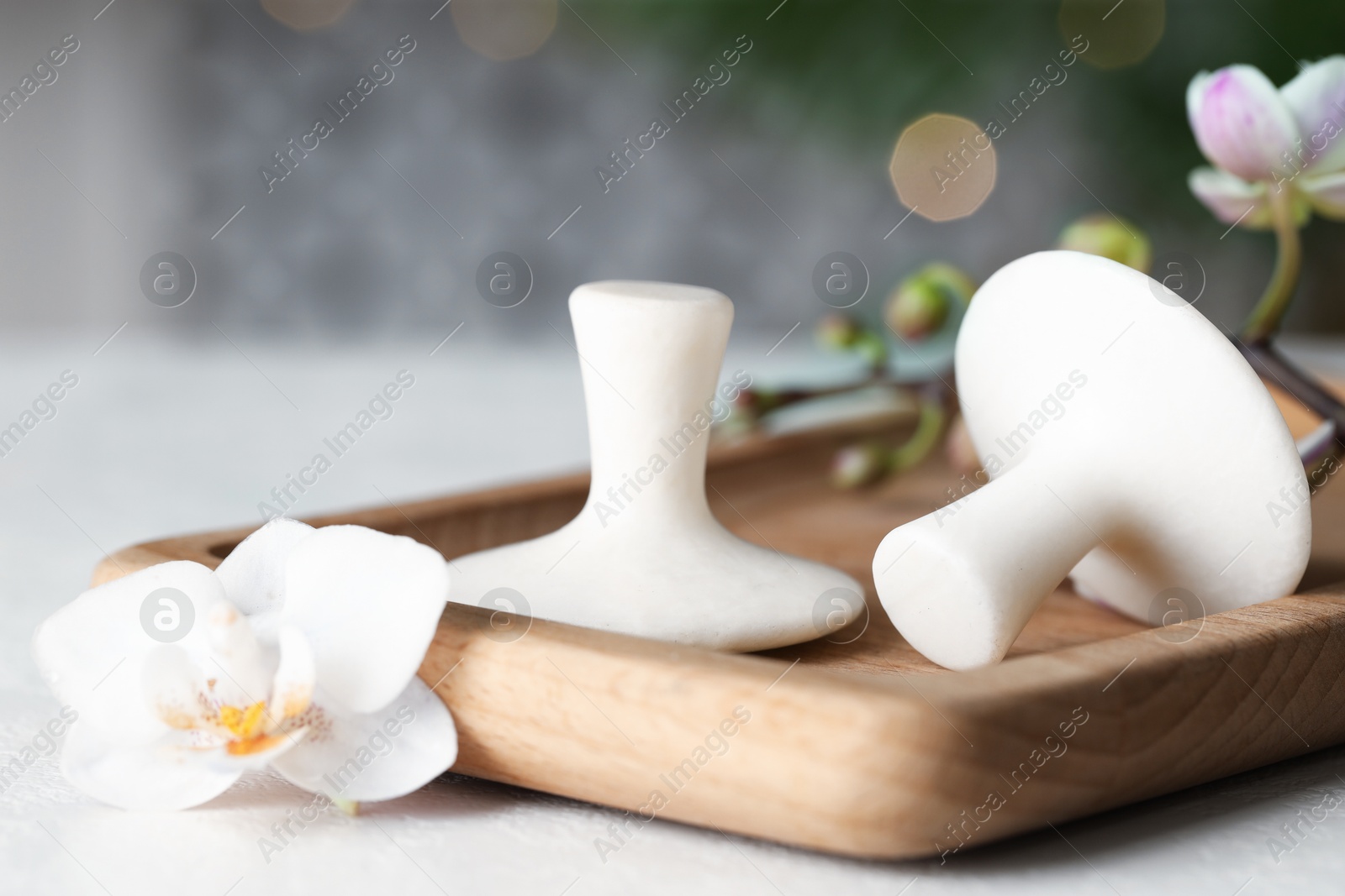 Photo of Spa stones and orchid flowers on white table, closeup