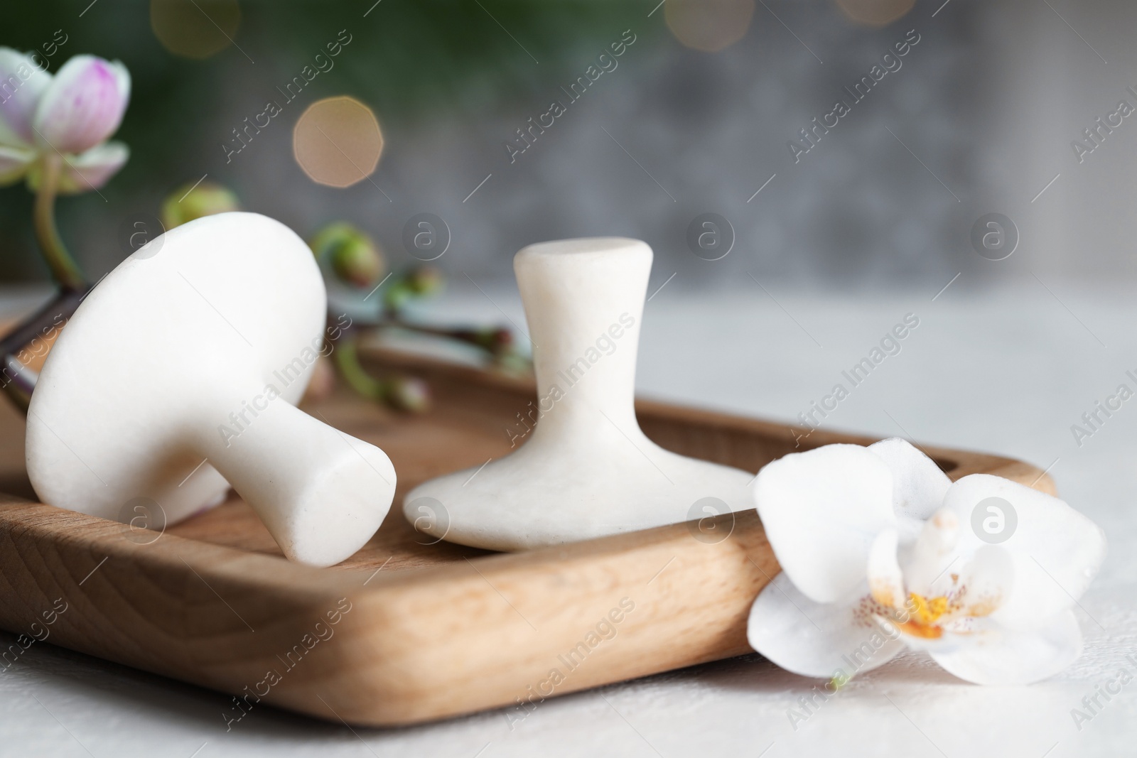 Photo of Spa stones and orchid flowers on white table, closeup