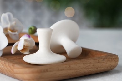 Photo of Spa stones and orchid flowers on white table, closeup