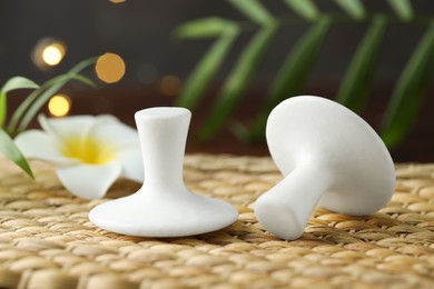 Photo of Spa stones and plumeria flower on wicker mat, closeup