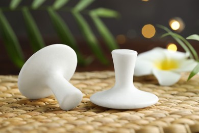 Photo of Spa stones and plumeria flower on wicker mat, closeup