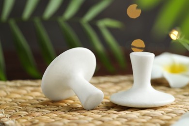 Photo of Spa stones and plumeria flower on wicker mat, closeup