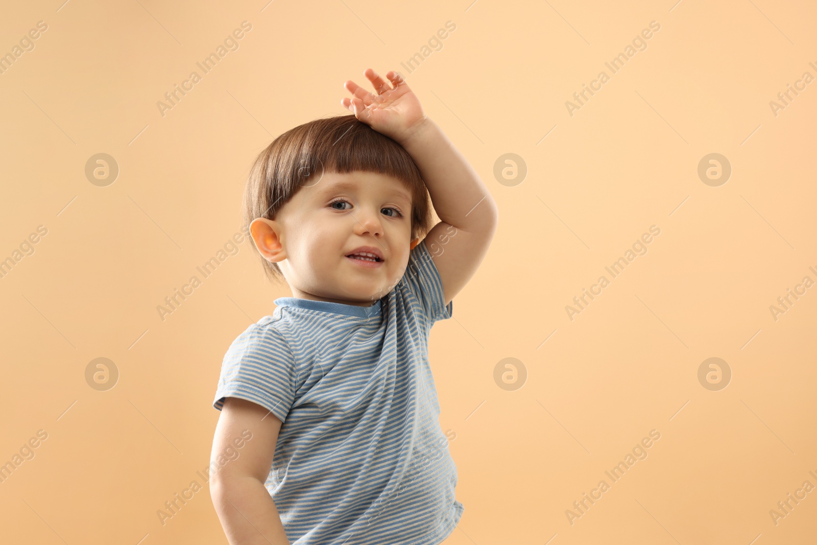 Photo of Portrait of cute little boy on beige background. Space for text