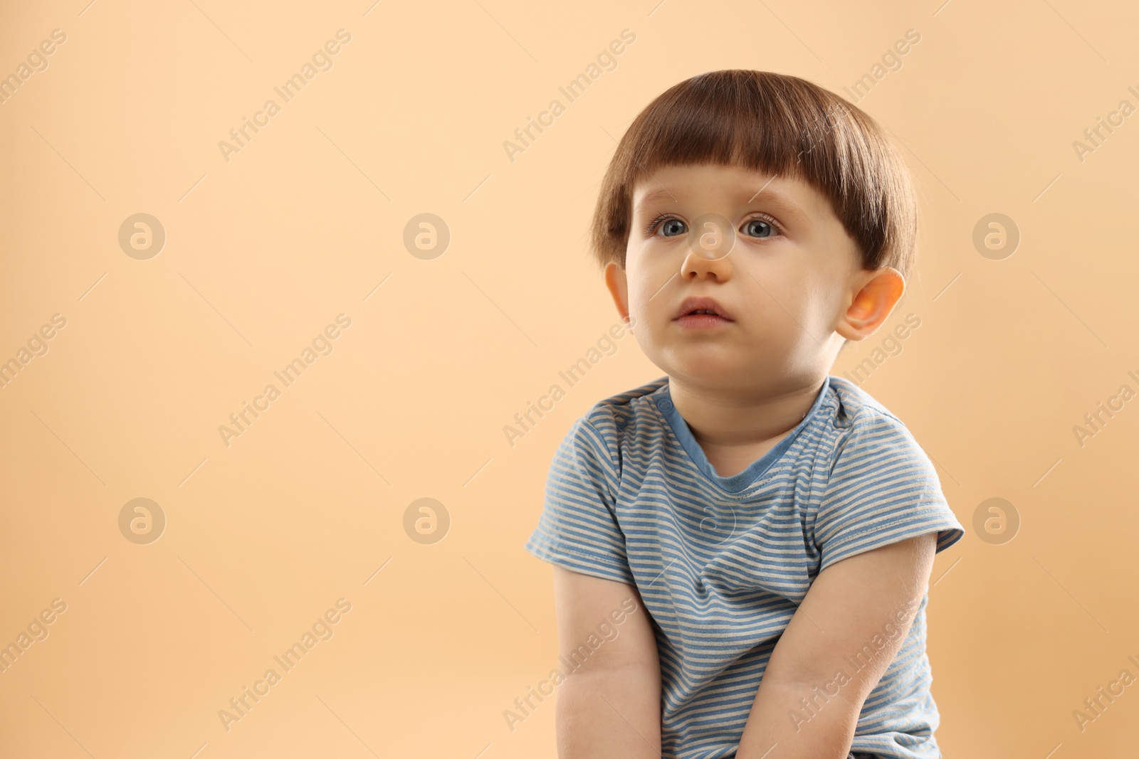 Photo of Portrait of cute little boy on beige background. Space for text