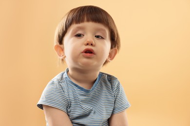 Photo of Portrait of cute little boy on beige background