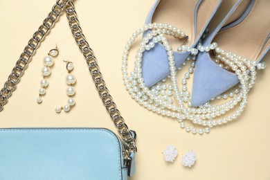 Photo of Flat lay composition with jewelry, accessories and shoes on beige background