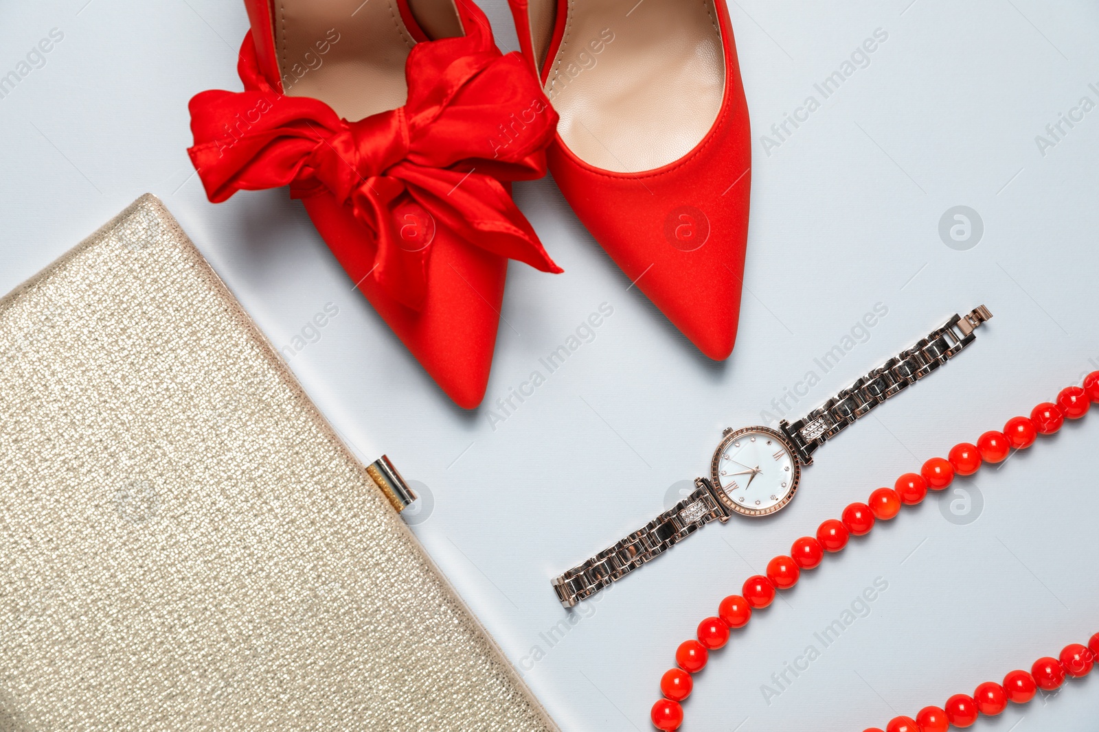 Photo of Stylish shoes, watch, necklace and purse on light grey background, flat lay