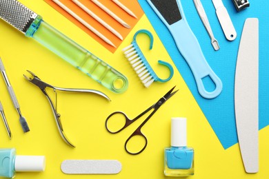 Photo of Set of pedicure tools on color background, flat lay