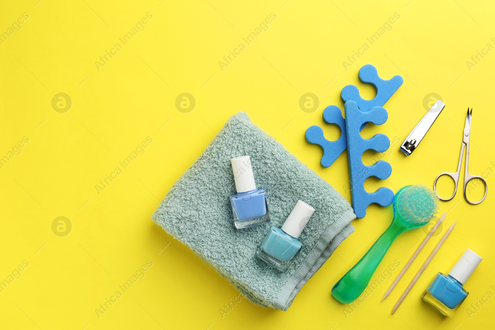 Photo of Set of pedicure tools on yellow background, flat lay. Space for text